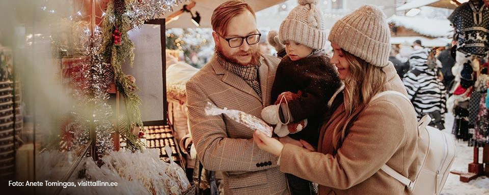 En familj tittar på pepparkakor på Tallinns julmarknad